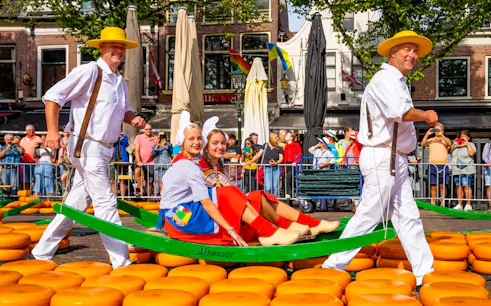Cheese carriers at Alkmaar Cheese Market with traditional costumes and cheese wheels.
