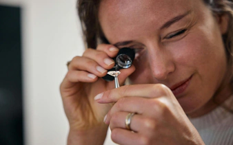 Examining a diamond with a loupe at the oldest diamond factory in the world.