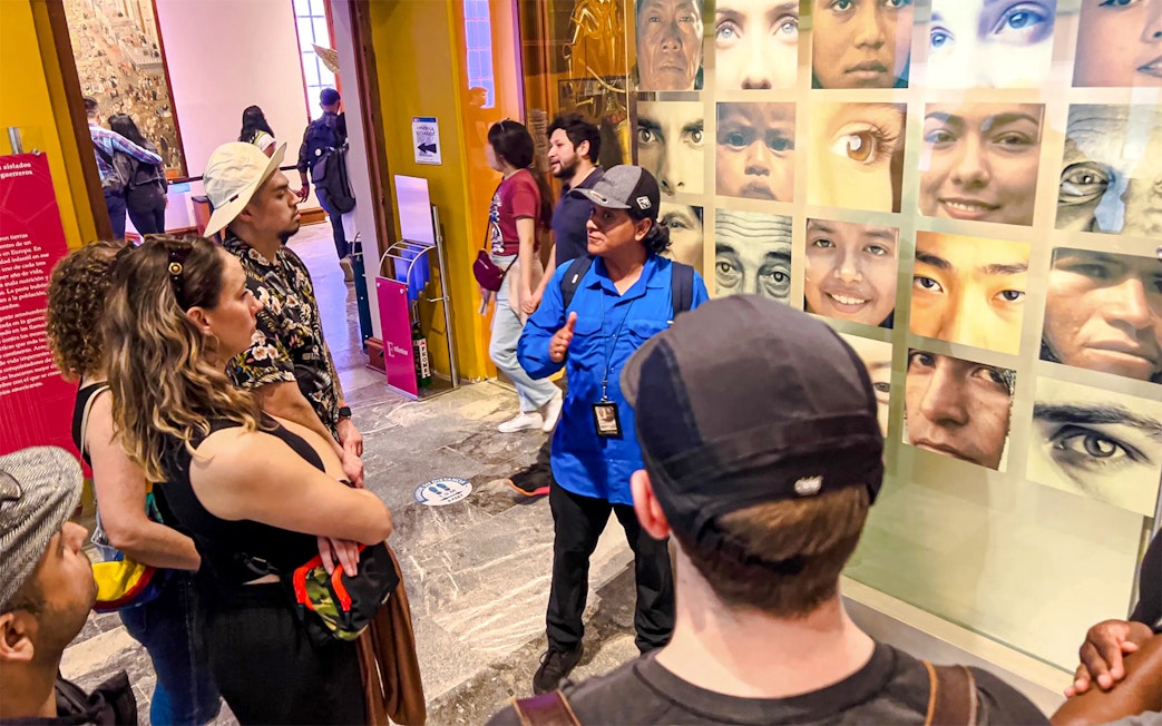 Visitors listening to a guide at the Anthropology Museum in Mexico City.
