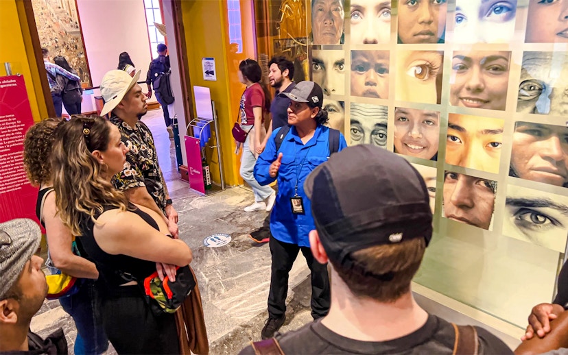 Visitors listening to a guide at the Anthropology Museum in Mexico City.