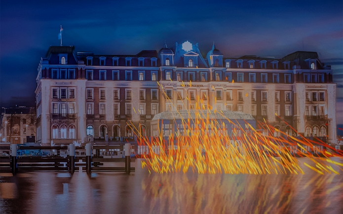 Amsterdam Light Festival installation with illuminated building and reflections on canal.