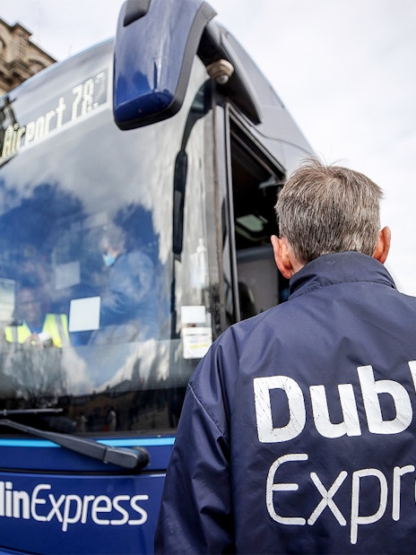 Dublin Express bus at stop with passengers boarding near Custom House Quay.