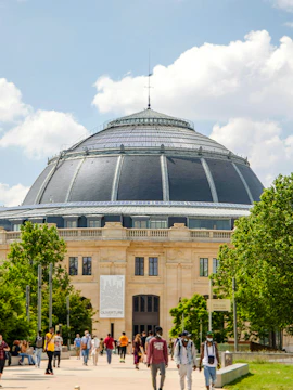 Exterior view of the Bourse de Commerce in Paris with people walking nearby.