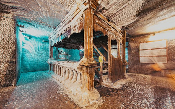Salina Turda salt mine interior with wooden structure and salt-covered walls, Romania.