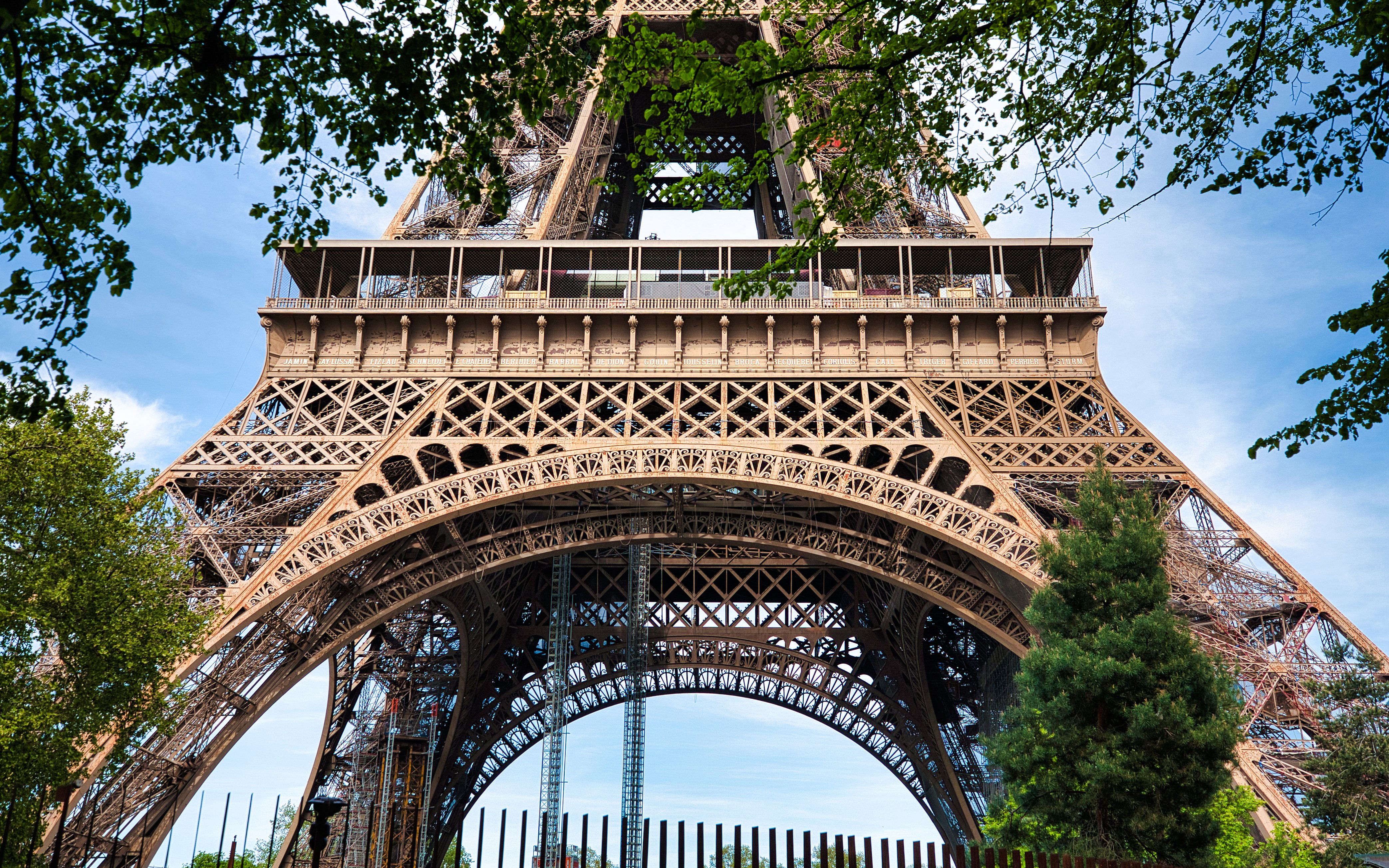 Closeup view of the Eiffel Tower's intricate iron lattice structure in Paris, France.