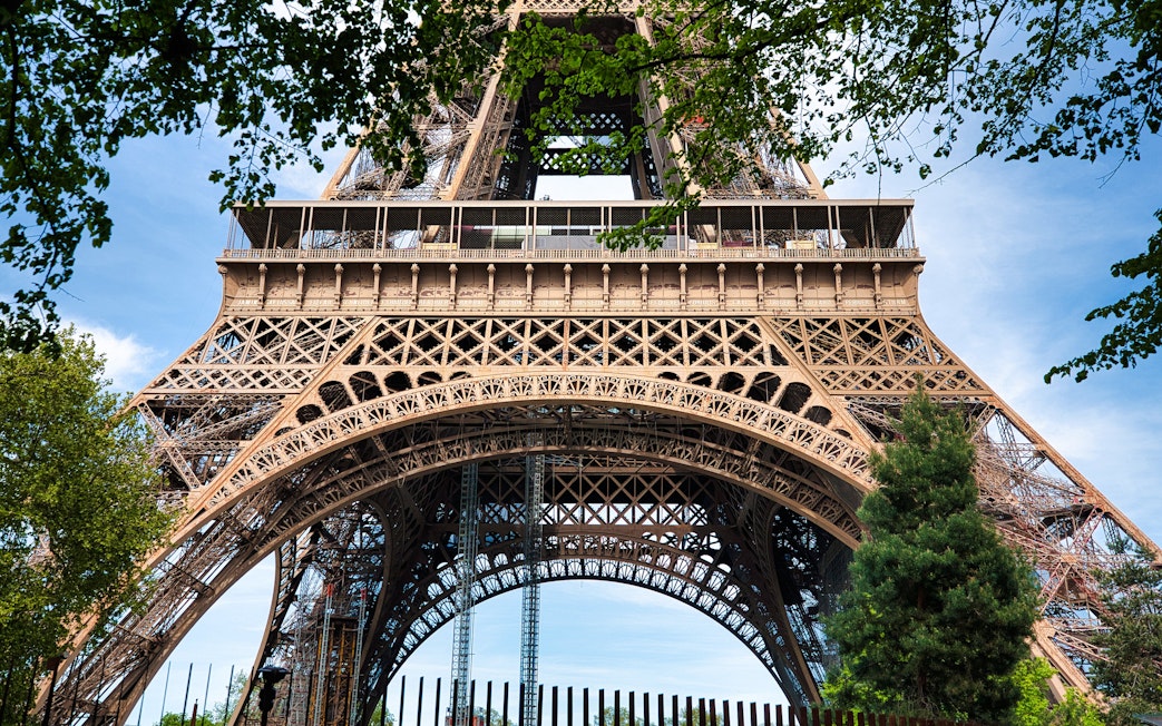Closeup view of the Eiffel Tower's intricate iron lattice structure in Paris, France.