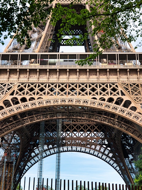 Closeup view of the Eiffel Tower's intricate iron lattice structure in Paris, France.