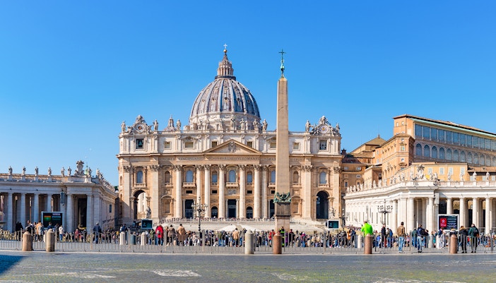 Vatican City St Peter's Basilica exterior with tourists in foreground.
