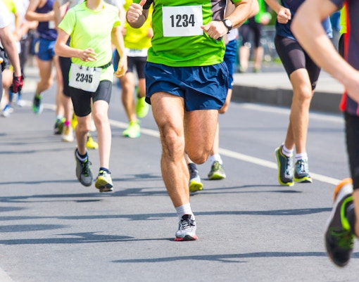 Runners participating in the Milan Marathon with the Duomo di Milano in the background.