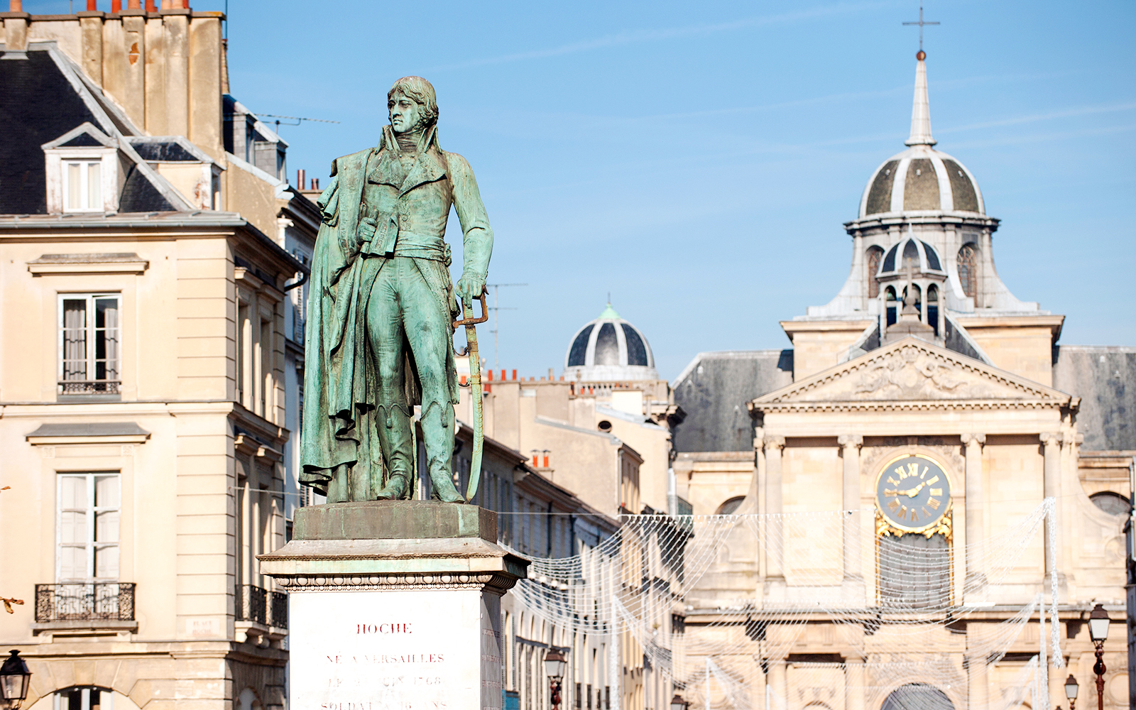Statue of General Hoche at Place Hoche, Versailles with historic buildings in the background.