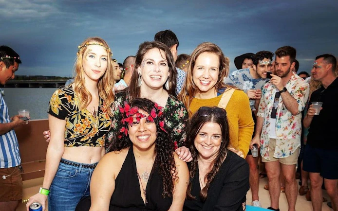 Group enjoying a party on a yacht cruise in Washington, DC with city views.