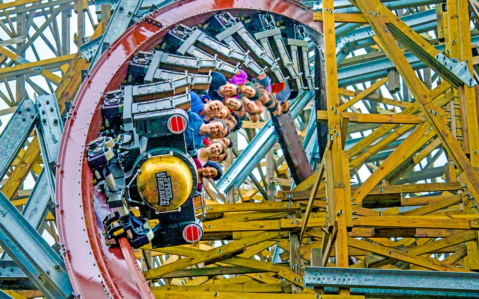 Riders on Steel Vengeance roller coaster at Cedar Point in a wooden structure loop.