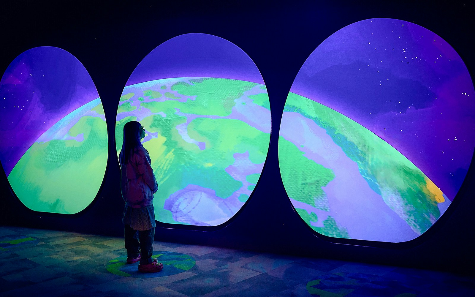 Visitor observing Earth display at Our Wondrous Planet exhibit, Melbourne Museum.