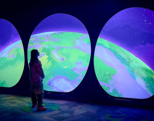 Visitor observing Earth display at Our Wondrous Planet exhibit, Melbourne Museum.
