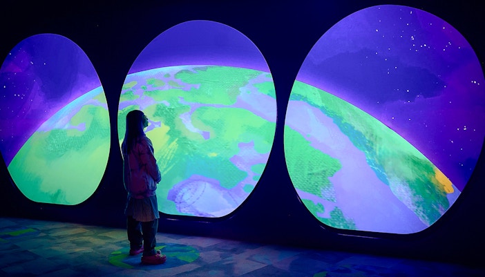 Visitor observing Earth display at Our Wondrous Planet exhibit, Melbourne Museum.