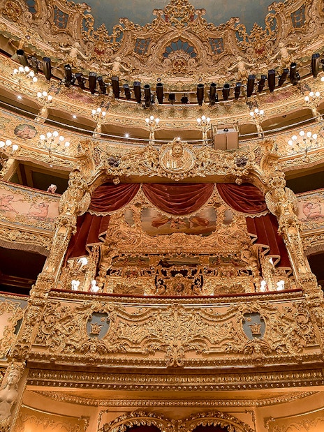 Ornate interior of Fenice Theater with gilded balconies and chandeliers.