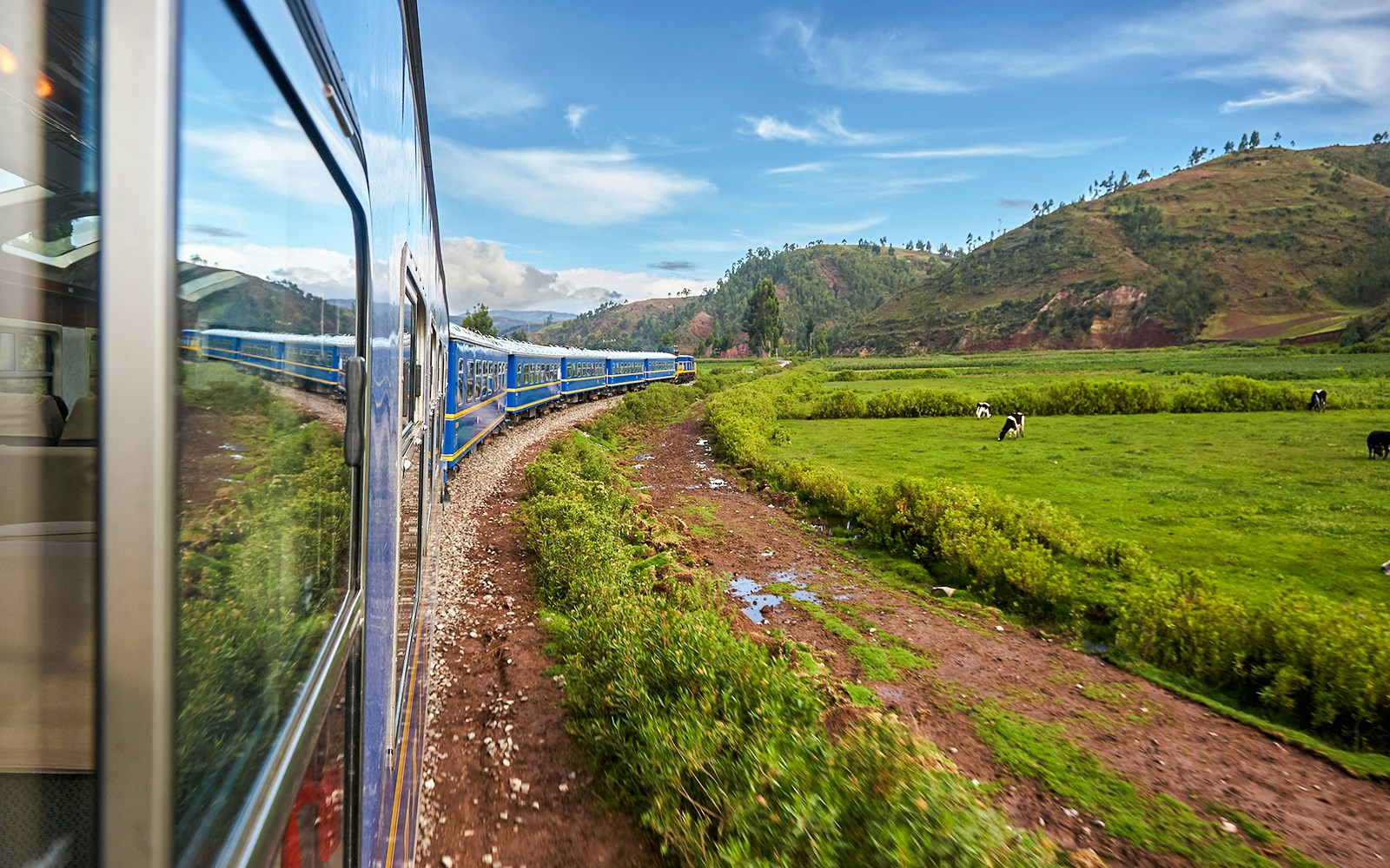 Train traveling through scenic landscape towards Machu Picchu, Peru.
