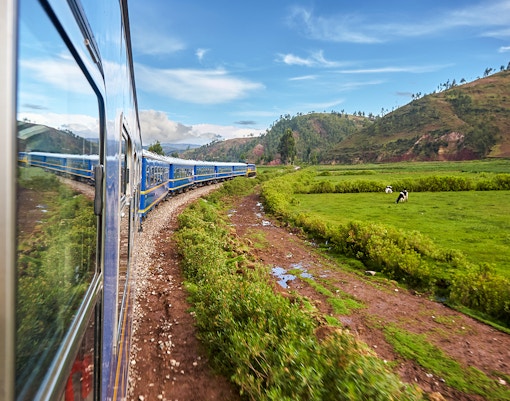 Train traveling through scenic landscape towards Machu Picchu, Peru.