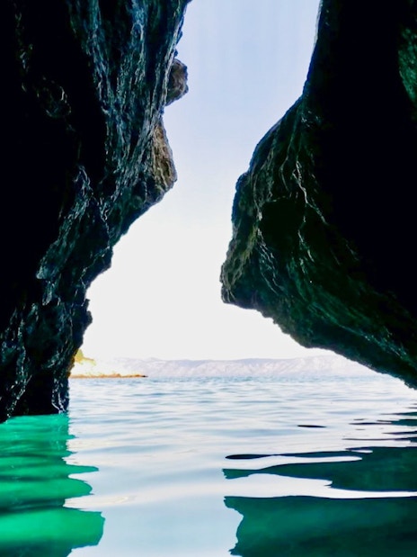 Hidden cave entrance with turquoise water on Hvar Island, Croatia.