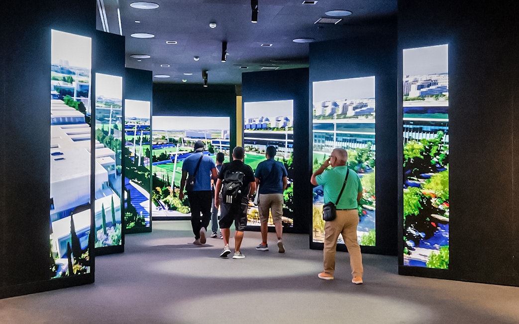 Tourists viewing digital displays at Santiago Bernabeu stadium exhibit.