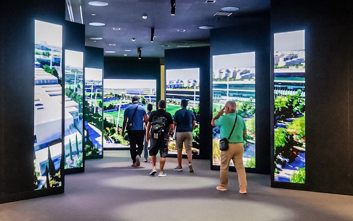 Tourists viewing digital displays at Santiago Bernabeu stadium exhibit.