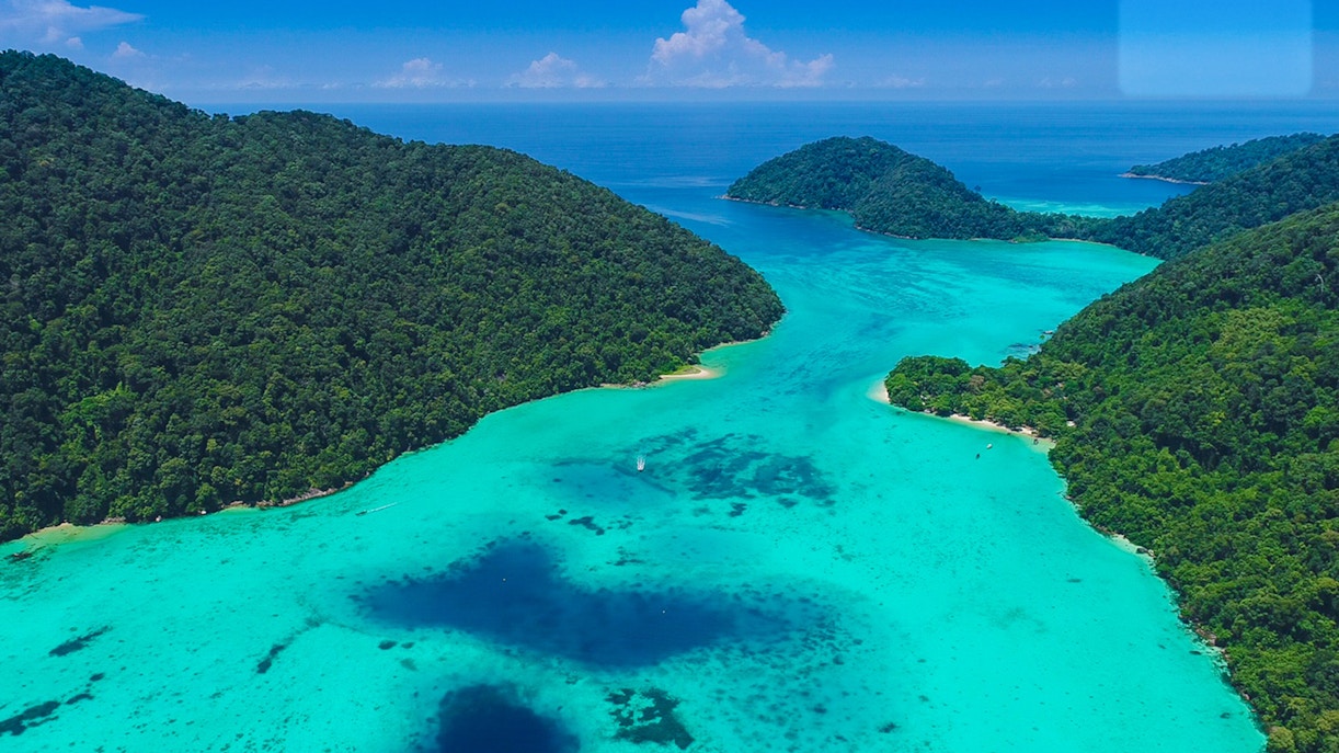Aerial view of Surin Islands' lush green coastline and turquoise waters.