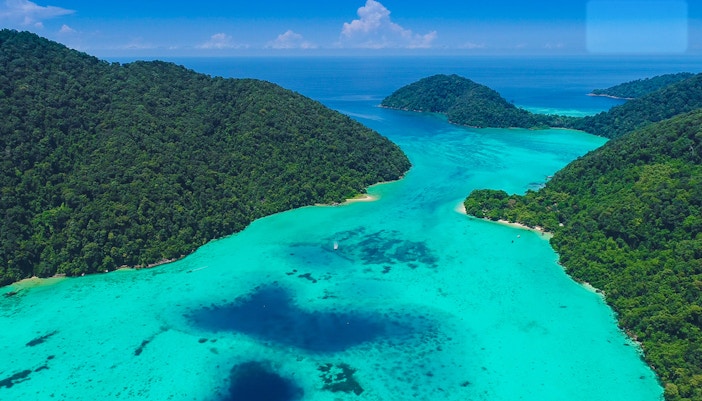 Aerial view of Surin Islands' lush green coastline and turquoise waters.