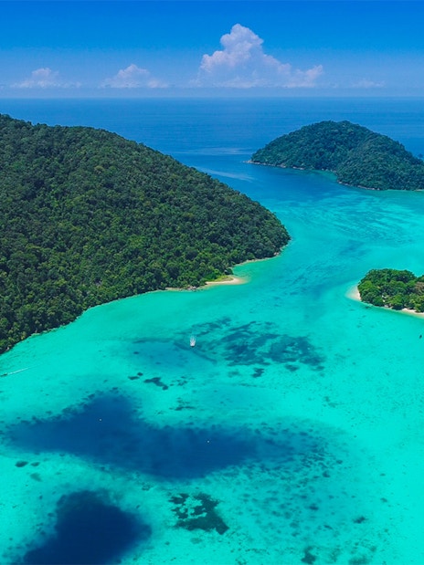 Aerial view of Surin Islands' lush green coastline and turquoise waters.