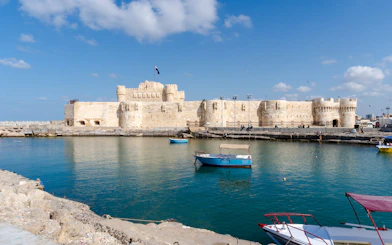 Citadel of Alexandria viewed from the sea with boats on a sunny day.