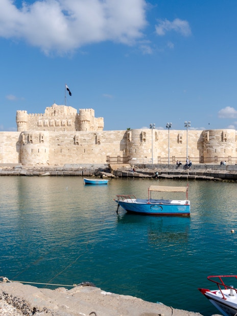 Citadel of Alexandria viewed from the sea with boats on a sunny day.