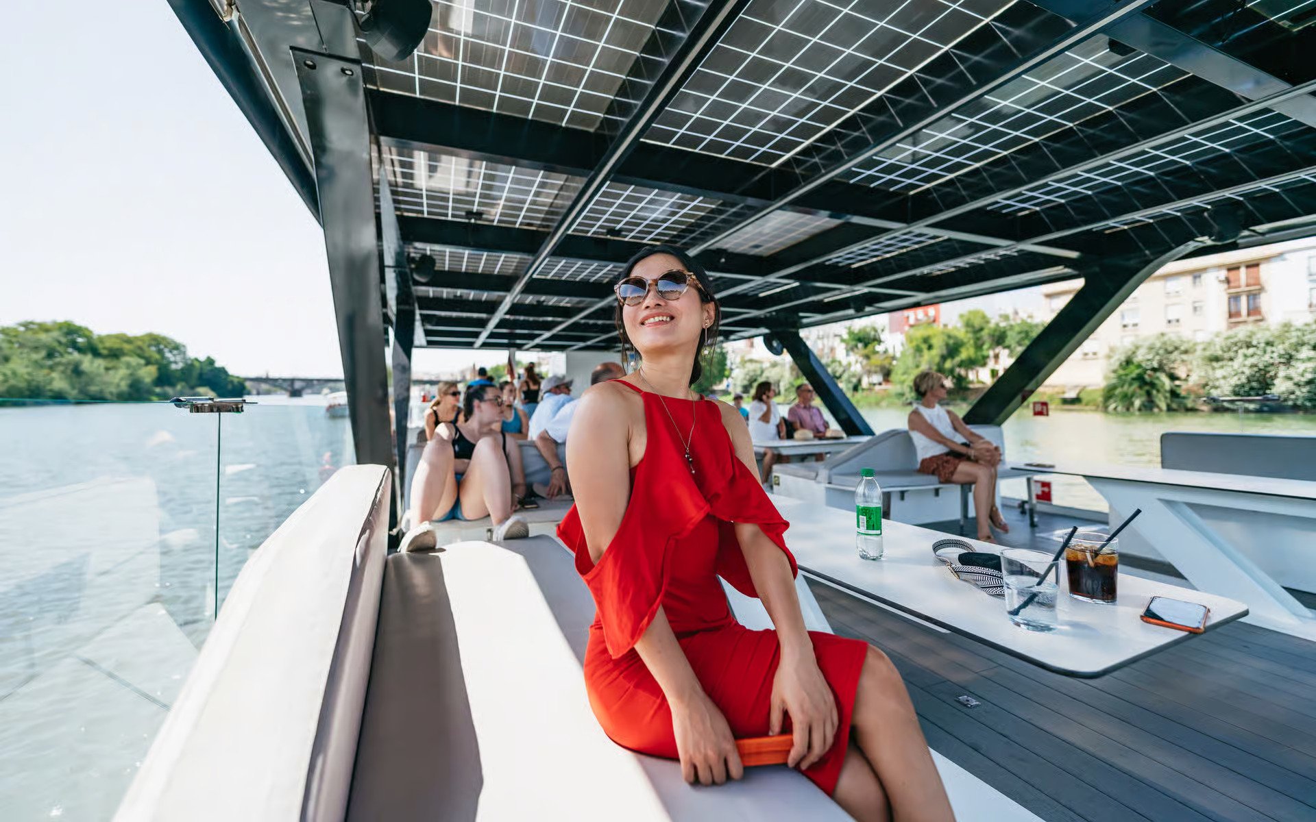 Tourists enjoying an eco-friendly cruise on the Guadalquivir River in Seville, Spain.