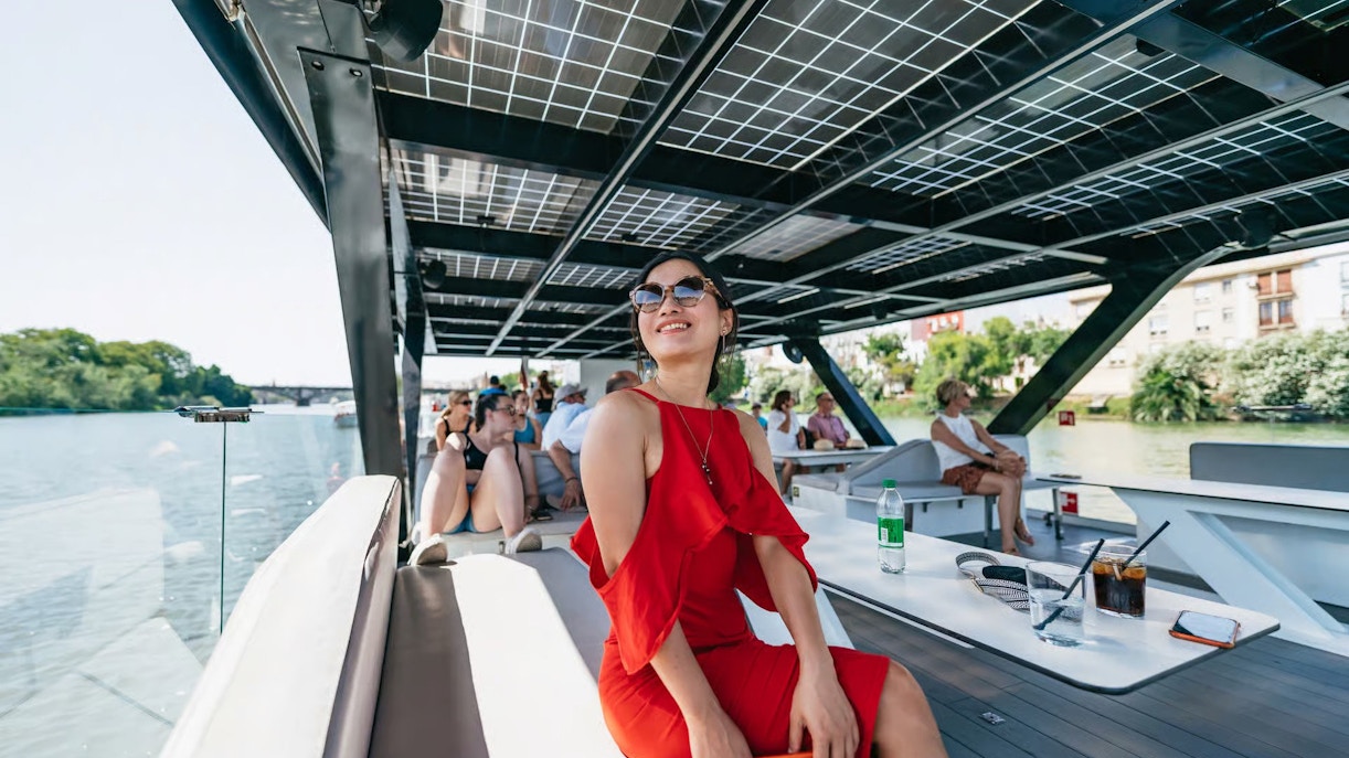 Tourists enjoying an eco-friendly cruise on the Guadalquivir River in Seville, Spain.