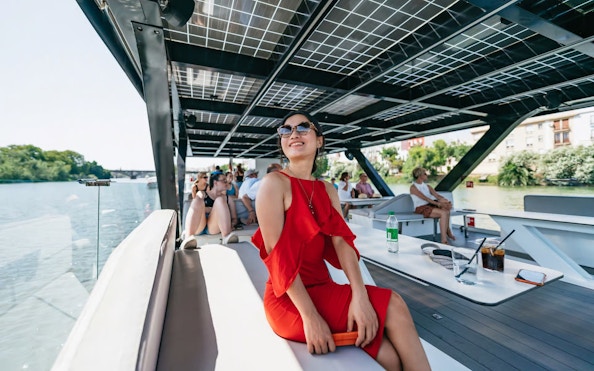 Tourists enjoying an eco-friendly cruise on the Guadalquivir River in Seville, Spain.