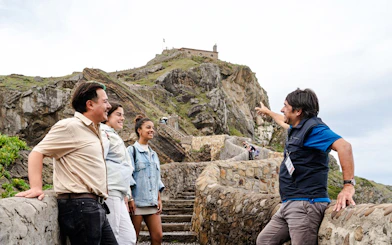Tour guide with group at San Juan de Gaztelugatxe, near San Sebastian.