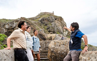 Tour guide with group at San Juan de Gaztelugatxe, near San Sebastian.