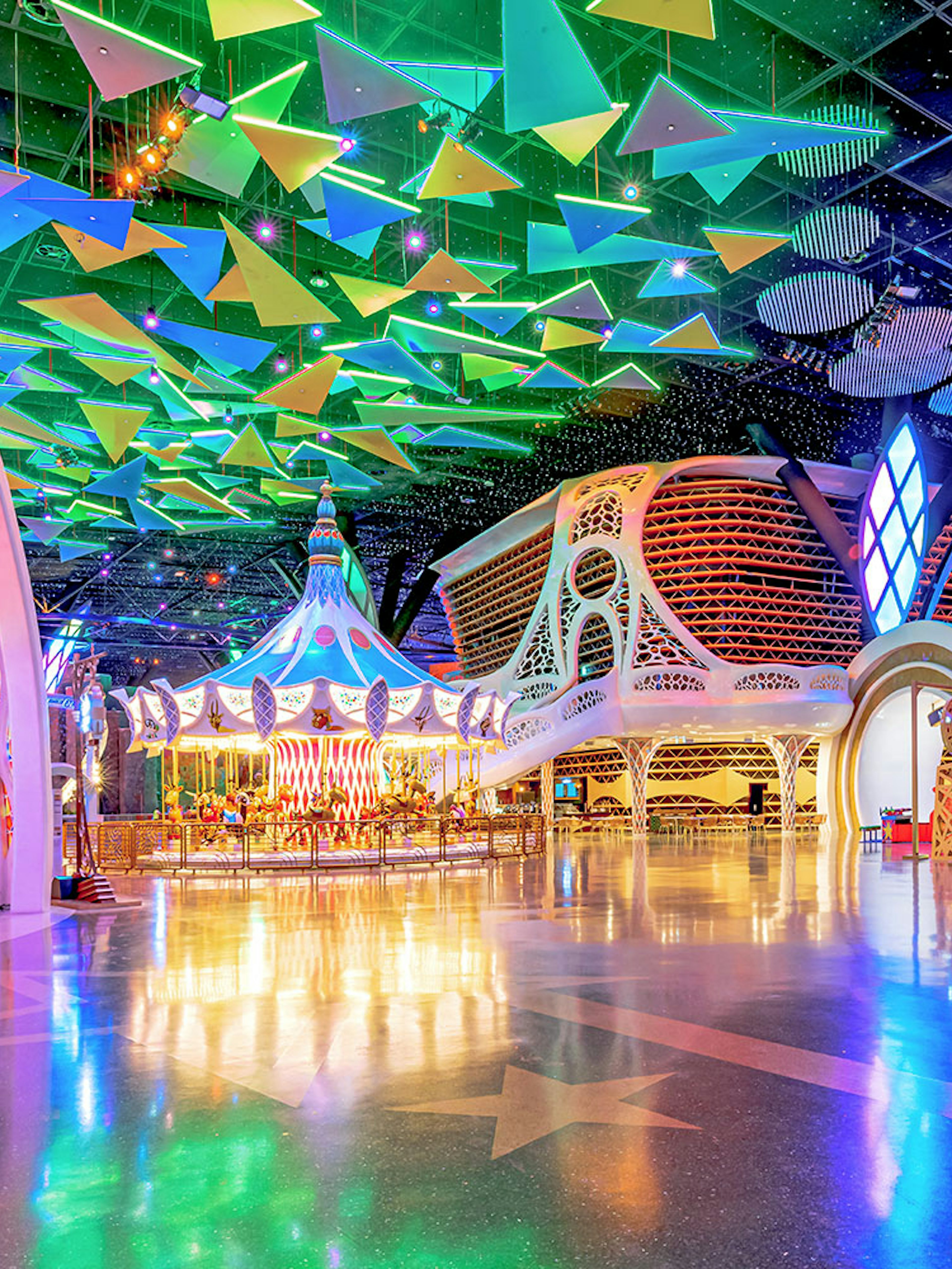 Doha Quest Theme Park interior with colorful carousel and geometric ceiling.
