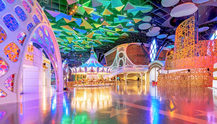Doha Quest Theme Park interior with colorful carousel and geometric ceiling.
