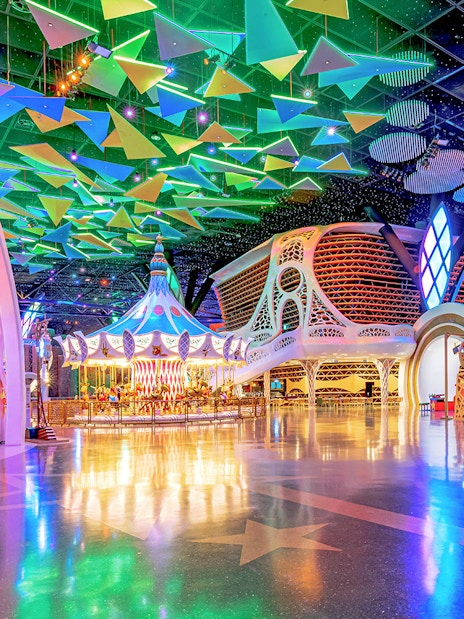 Doha Quest Theme Park interior with colorful carousel and geometric ceiling.