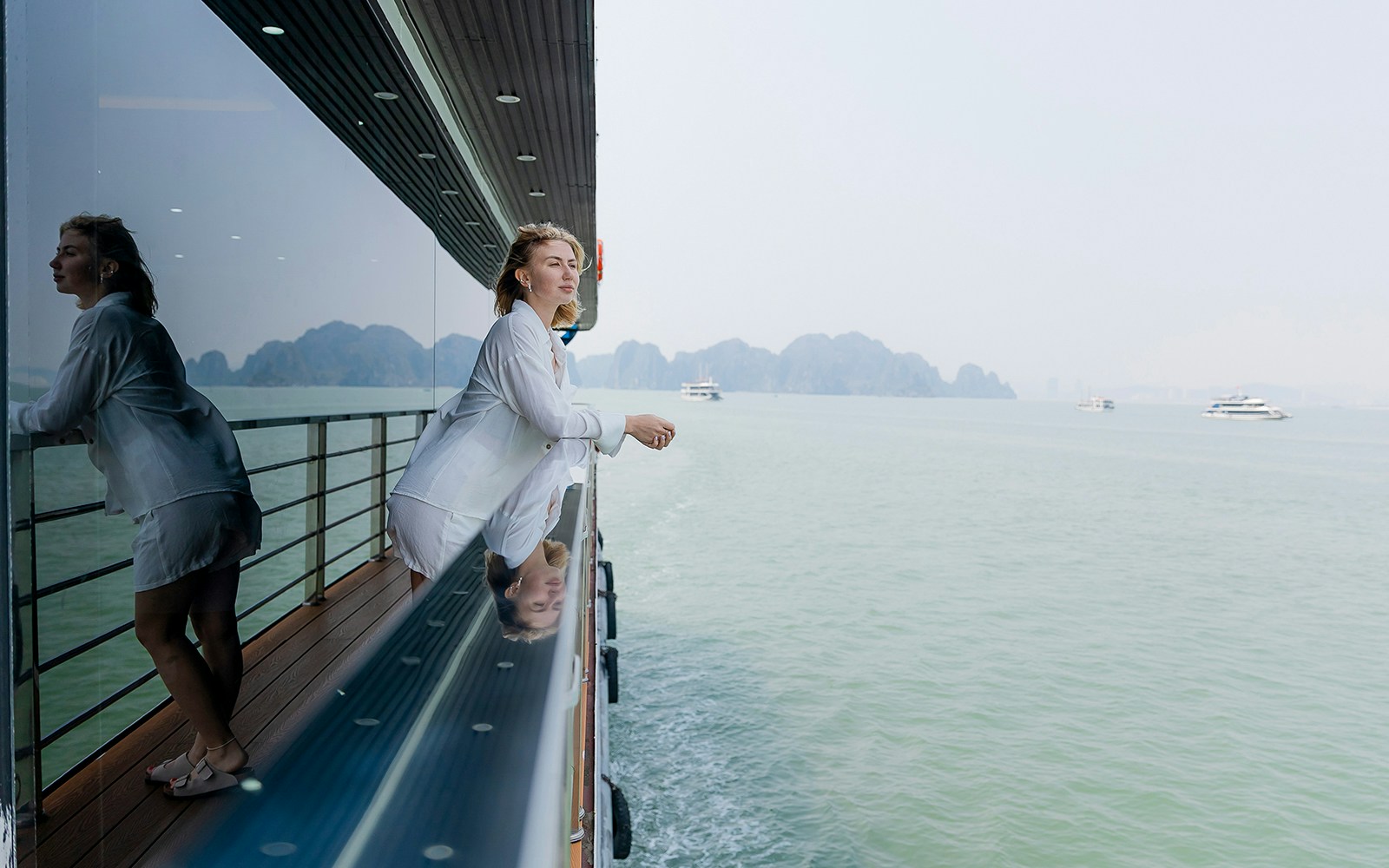 Young caucasian female enjoying scenic Halong bay views from cruise deck