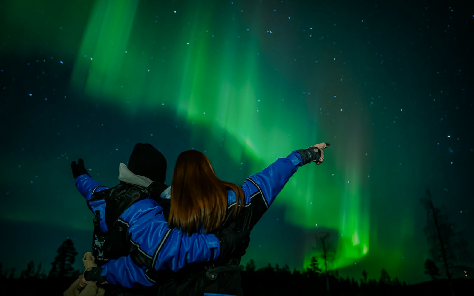 Couple watching Northern Lights in Levi, Finland.