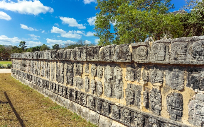 Stone carvings of skulls on the Platforms of the Skulls at Chichen Itza, Mexico.