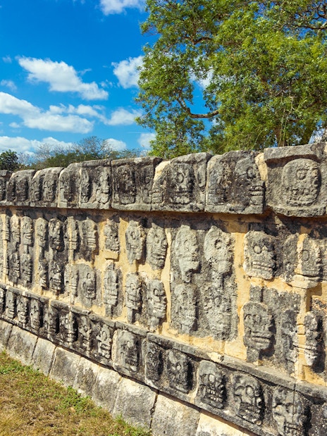 Stone carvings of skulls on the Platforms of the Skulls at Chichen Itza, Mexico.