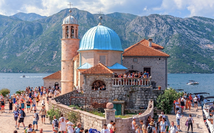 Our Lady of the Rocks church with tourists in Bay of Kotor, Montenegro.
