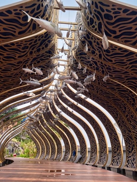Decorative archway with fish sculptures at Taman Safari Bali.