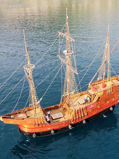 Game of Thrones ship replica sailing on clear blue waters.