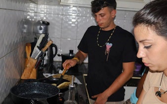 Cooking class participants preparing food in a kitchen at Diani Beach.