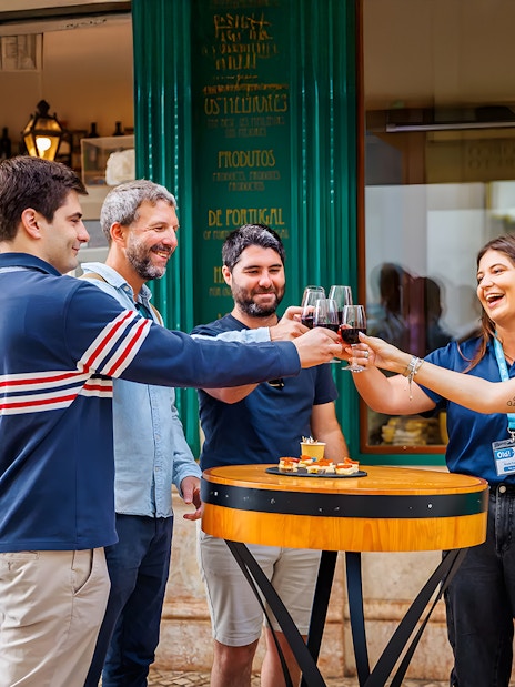 Tourists with guide enjoying drinks and food at a restaurant during Lisbon Food Walk in Baixa.