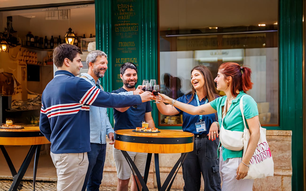 Tourists with guide enjoying drinks and food at a restaurant during Lisbon Food Walk in Baixa.