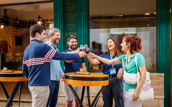 Tourists with guide enjoying drinks and food at a restaurant during Lisbon Food Walk in Baixa.