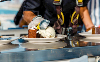 Scooping ice cream onto cake during Dinner in the Sky experience.
